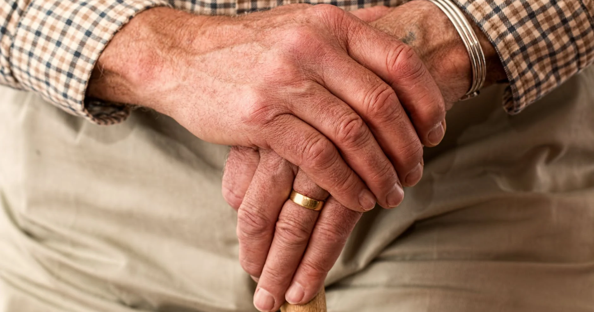 Les mains d'un aîné sur une canne