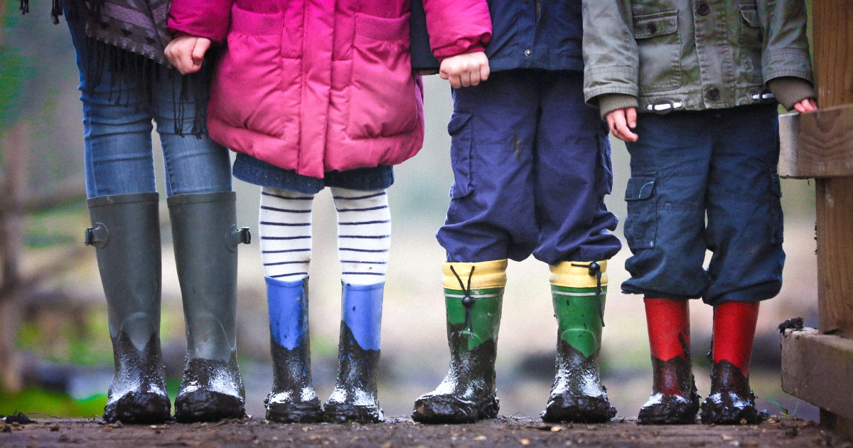 Des jambes d'enfants qui portent des bottes aux pieds