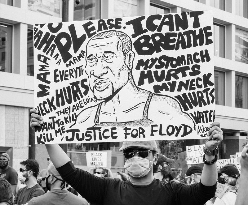 Un manifestant tient une pancarte à l'effigie de George Floyd