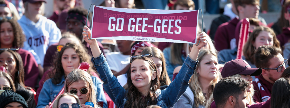 Un fan brandit un panneau sur lequel on peut lire Go Gee-Gees lors du match des Pandas.