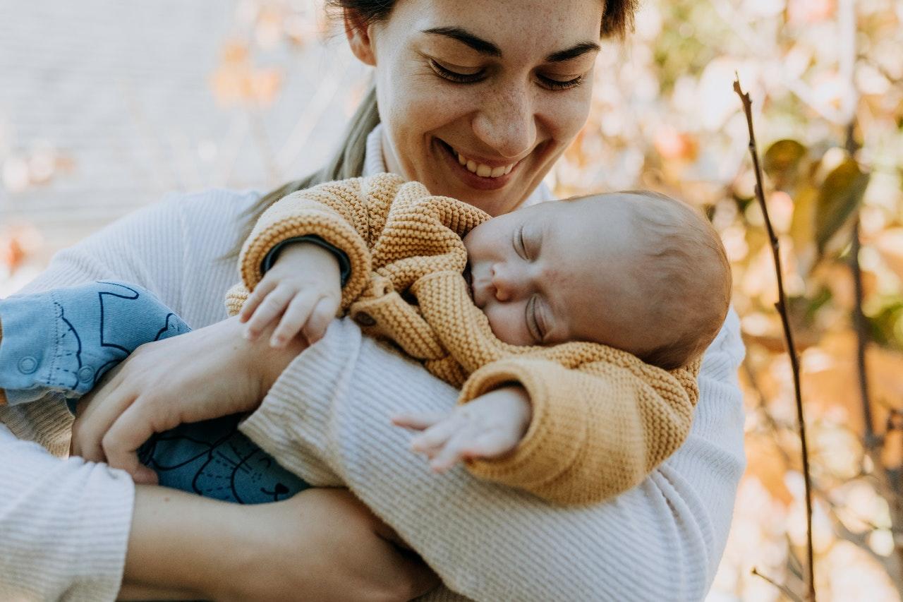 Femme berçant son bébé a l'extérieur