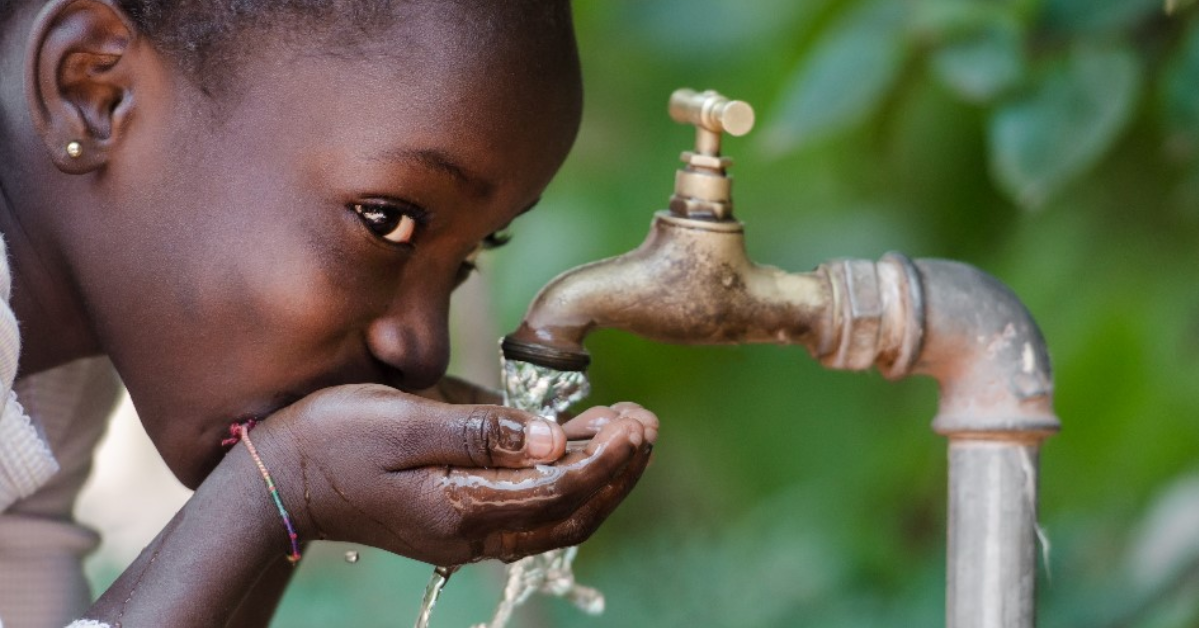Un enfant qui boit de l'eau d'un robinet
