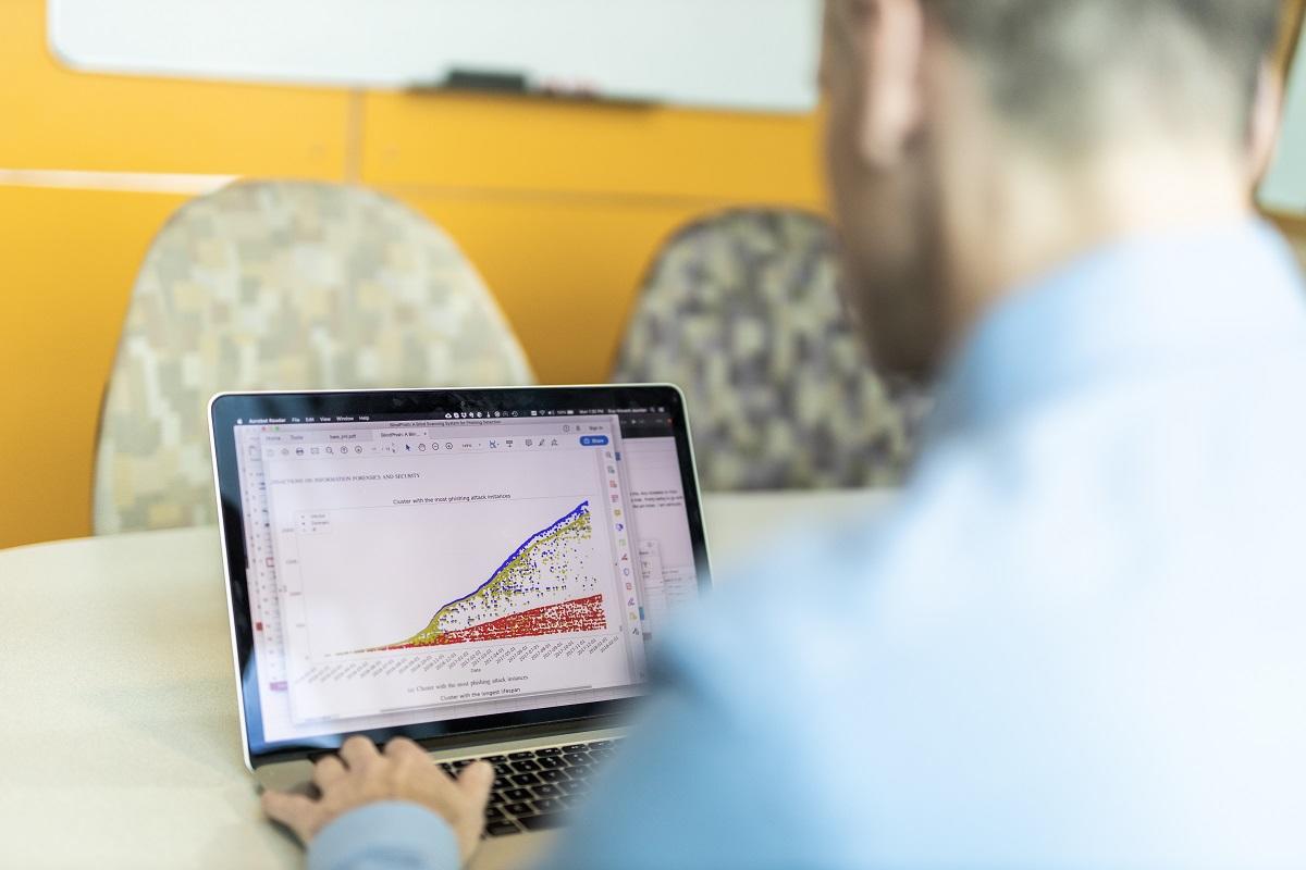 Vue de dos du professeur Guy-Vincent Jourdan utilisant un ordinateur