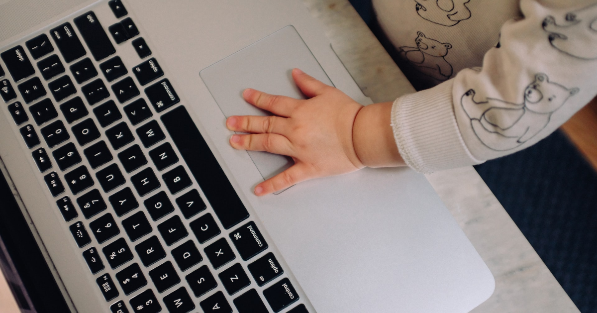 Une main d'enfant sur un ordinateur