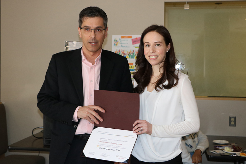 A professor receives an award from another professor.