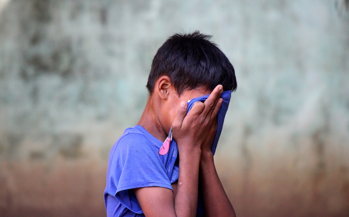 Rohingya boy with head in hands