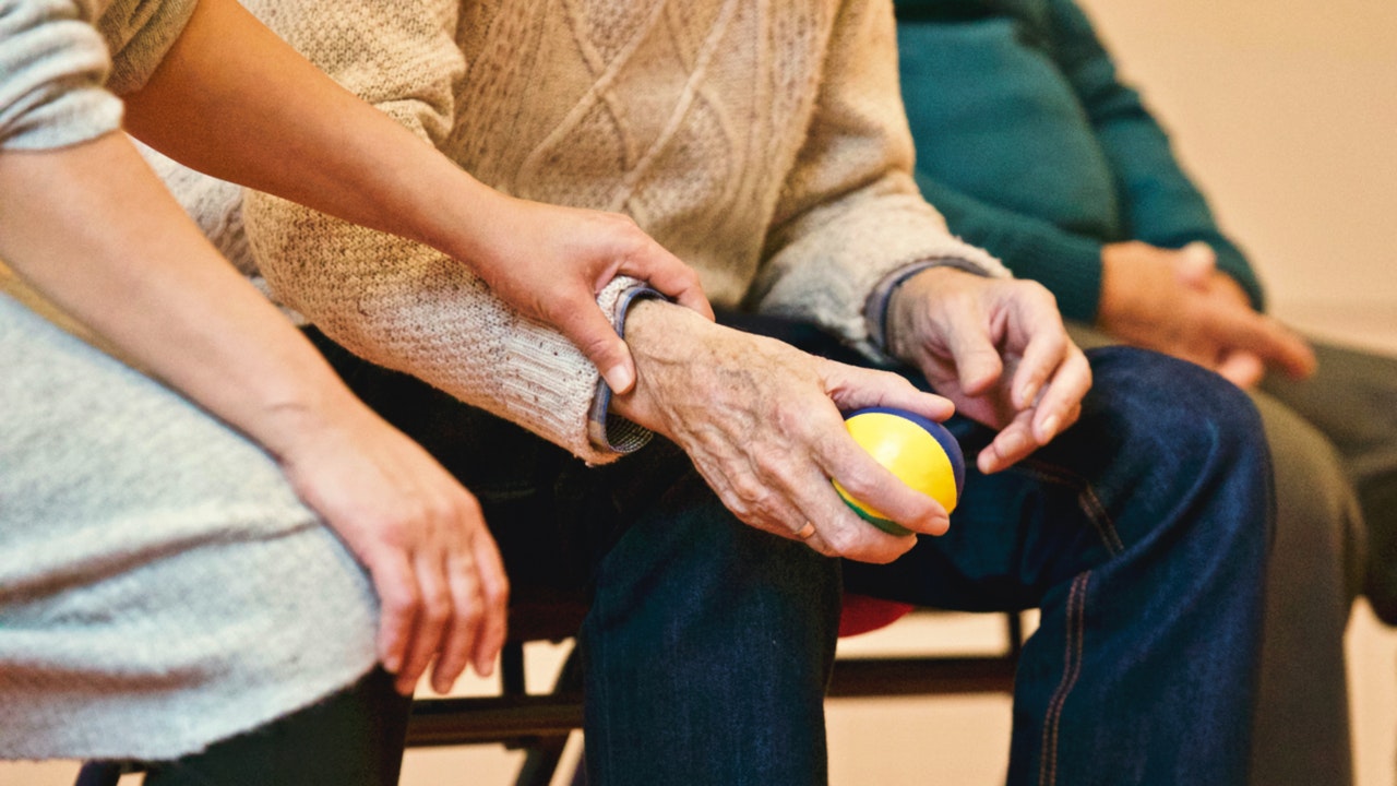 Someone holding the hand of an elder