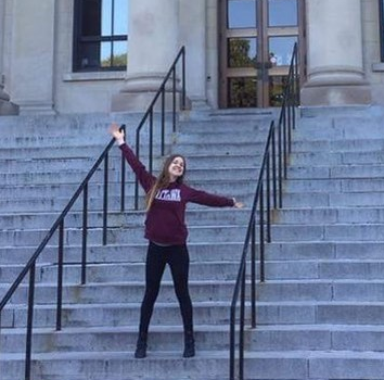 rxseyyy in front staircase outside of Tabaret with arms up in the air