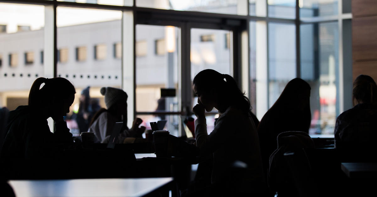 Backlighted students in a coffee shop.