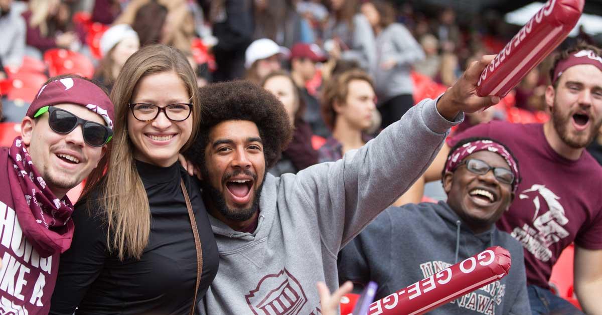 Peter Soroye with an afro cheering on the Gee-Gees at a Panda Game
