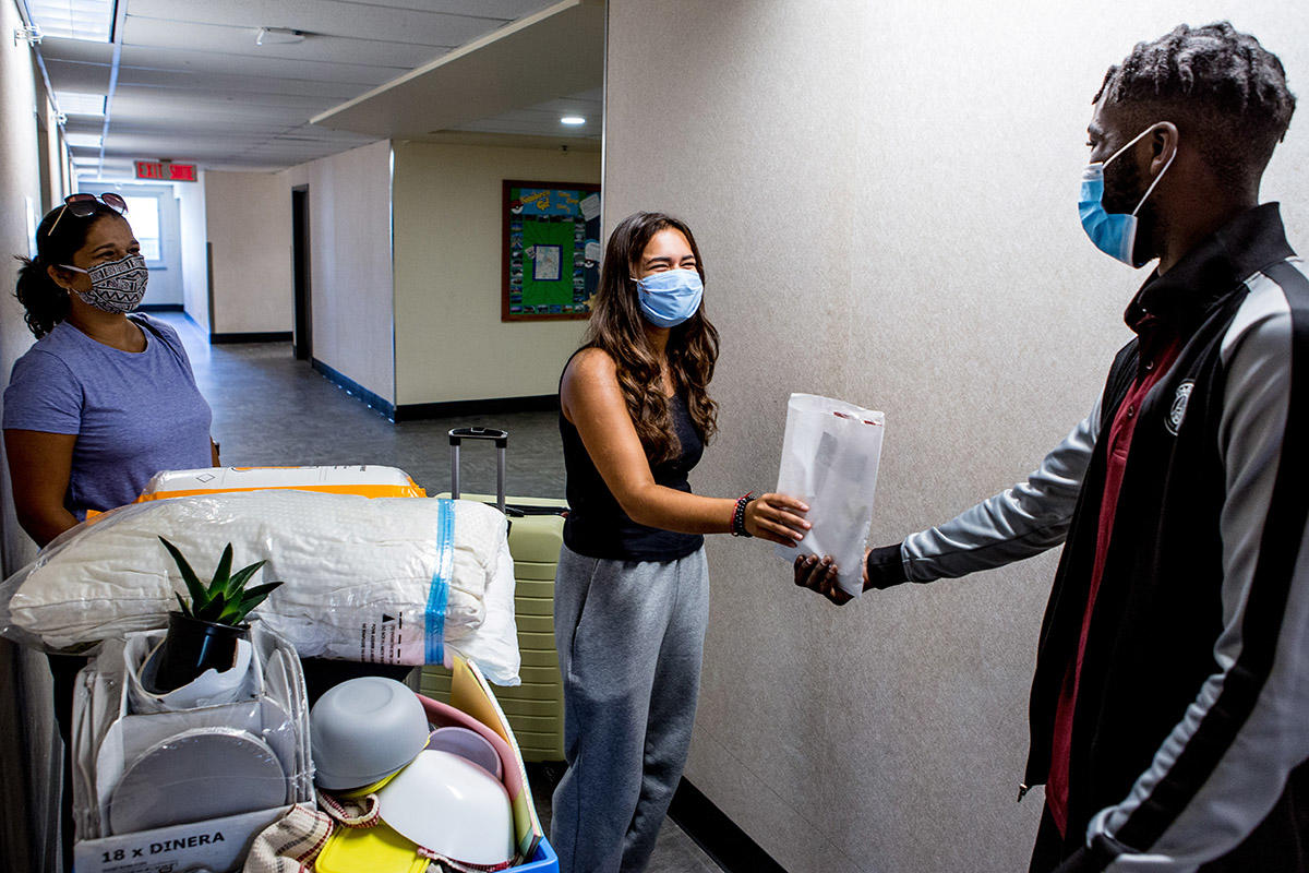 Le conseiller résident Tij remet en main propre le kit de bienvenue au nouvel étudiant.