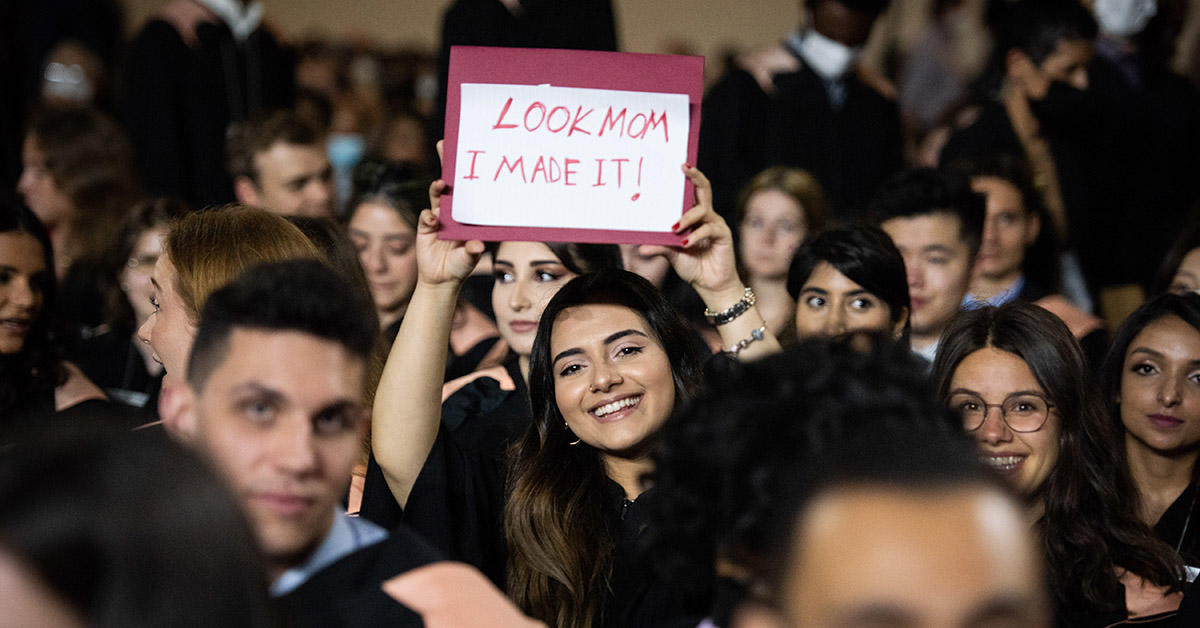 Telfer graduate holding sign 