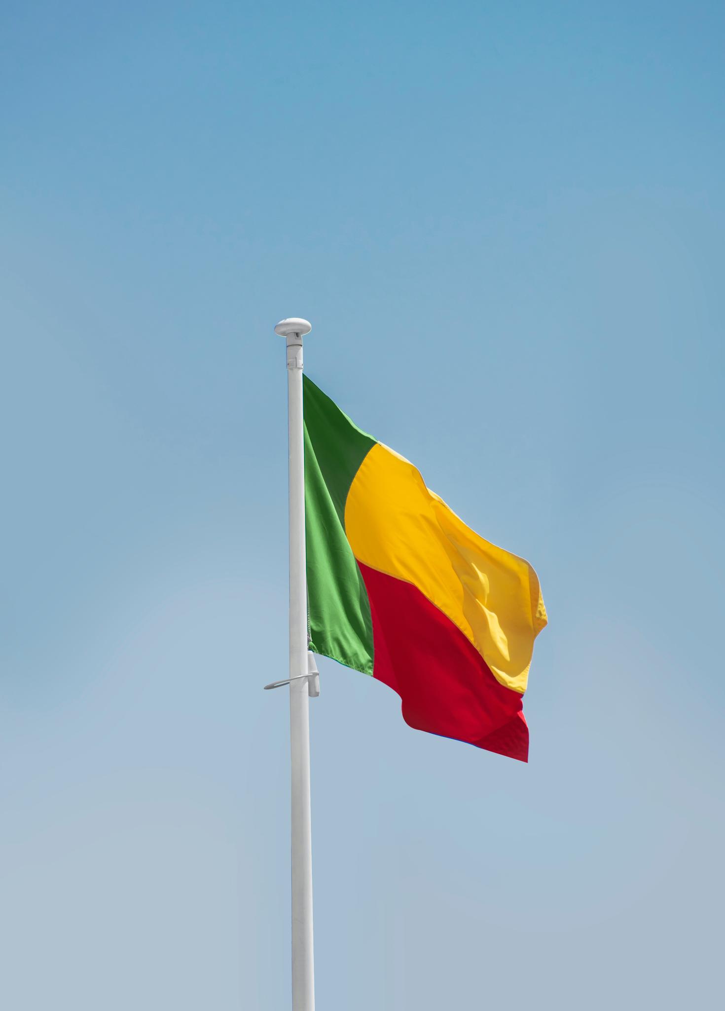 Beninese flag floating in the air with the sky in background