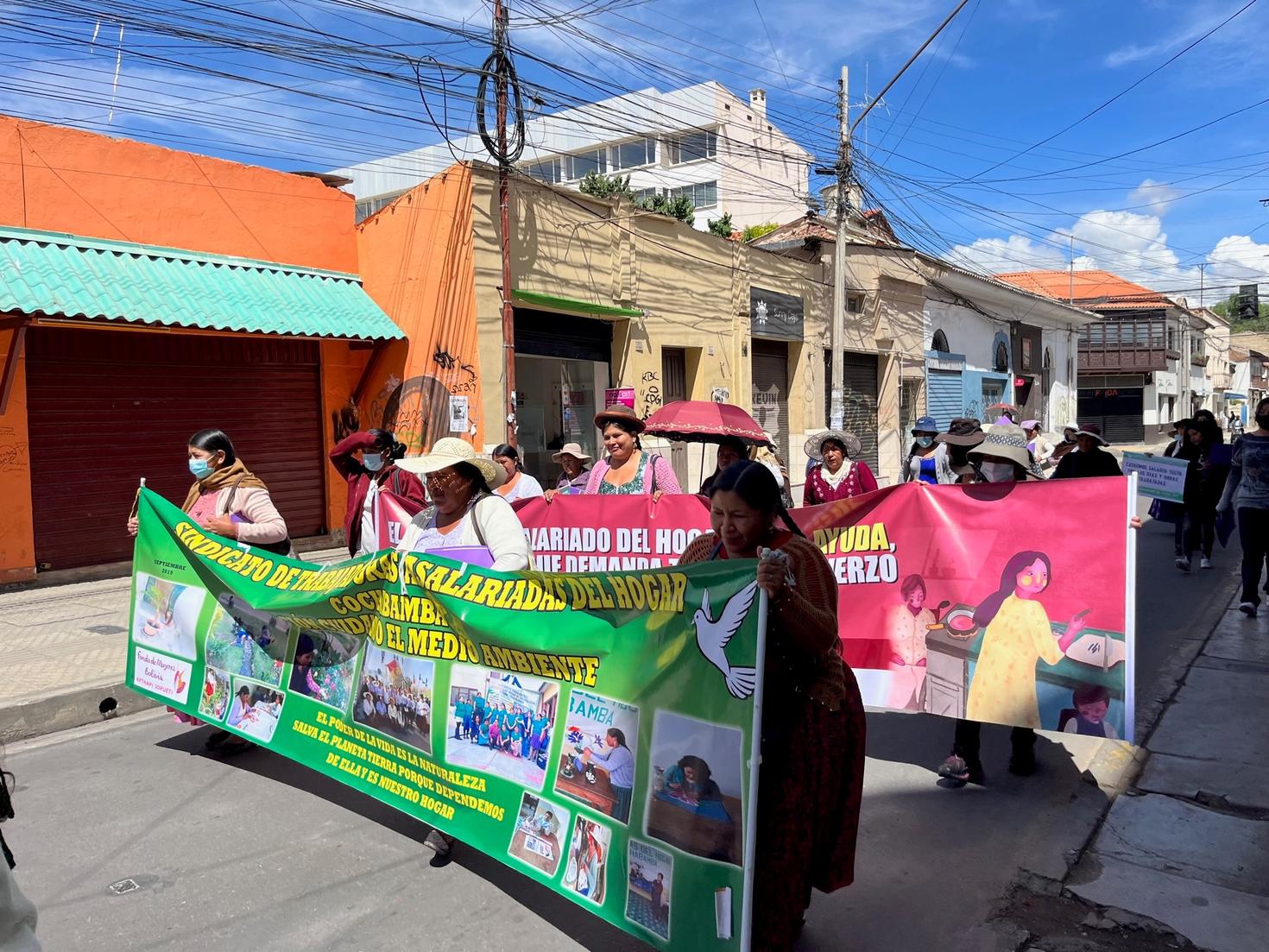 Bolivian women marching in the street holding banners