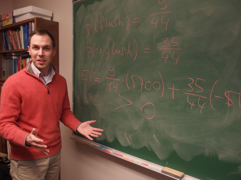 Professor Pieter Hofstra, standing in front of a chalkboard on which we can see mathematical formulas relating to his famous Poker 101 course.