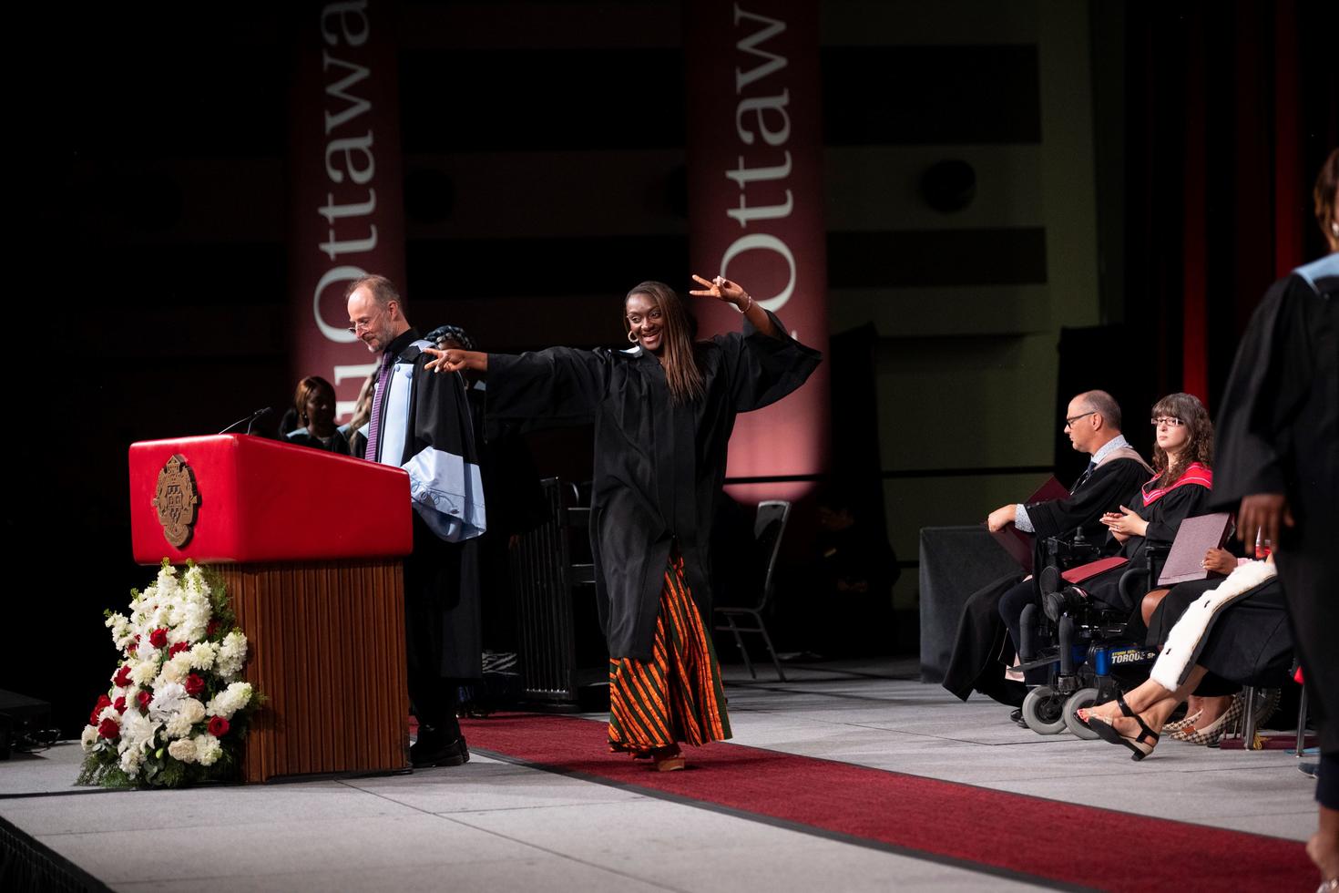 graduating student on stage during convocation ceremony