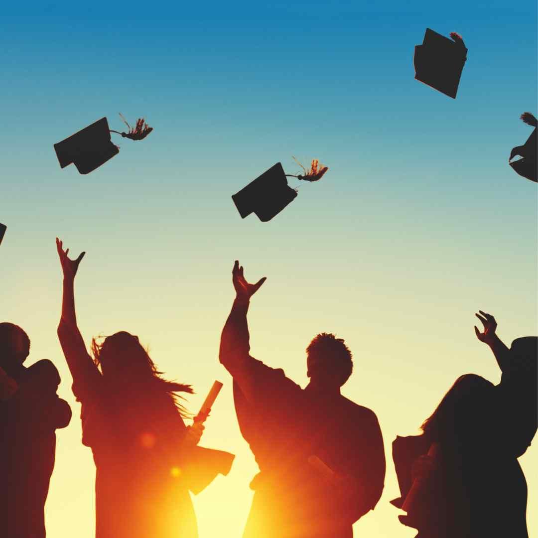 students throwing graduation caps in the air 
