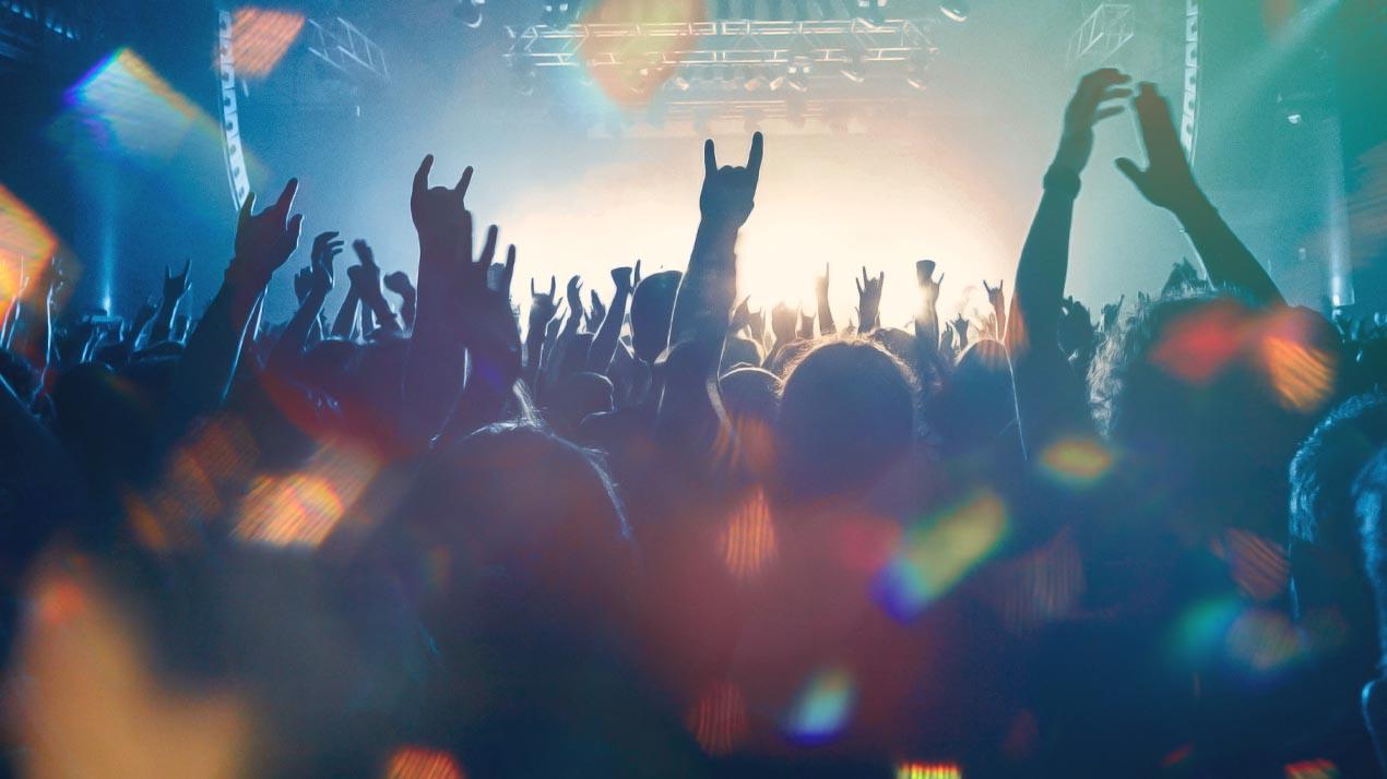 Une foule dansant avec les mains et les bras en l'air
