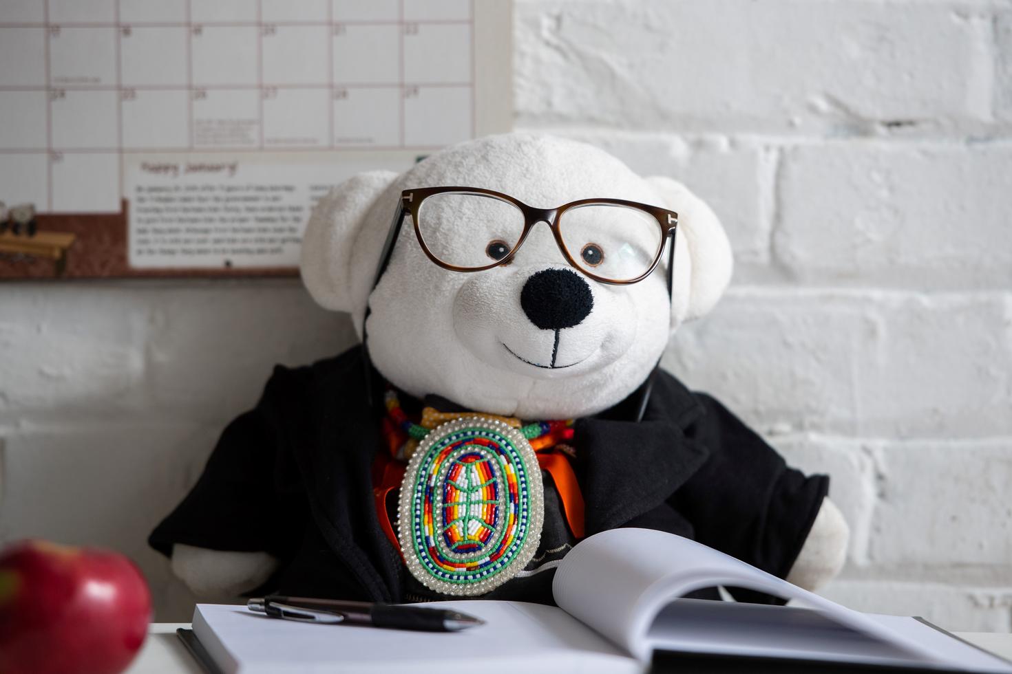 Ours en peluche lisant un livre.