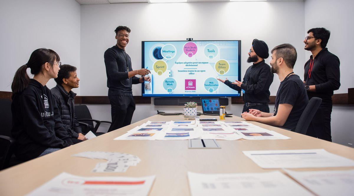 A group of employees work in a meeting room.