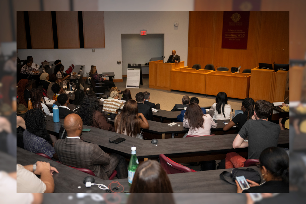 a room full of people listen to the lecture by Chief Justice Tulloch