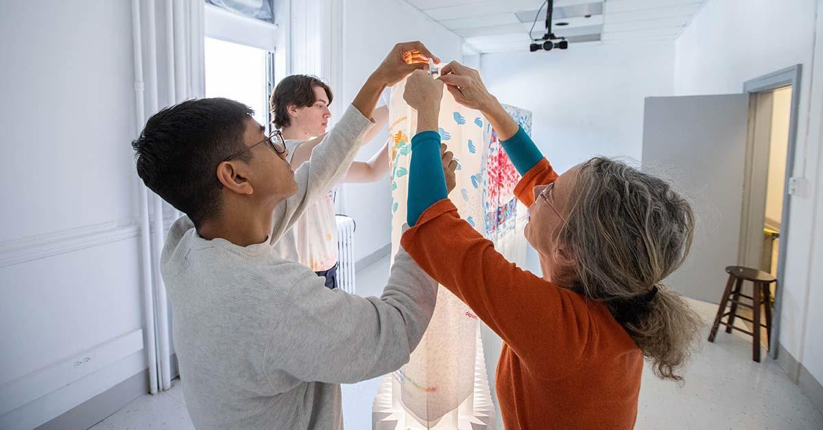 Jennifer Macklem, Willem Deisinger, and Devansh Shah working on their art installation
