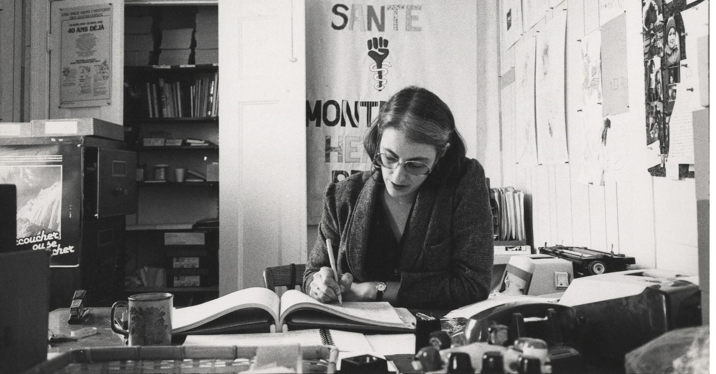 Black and white image of a woman working at desk