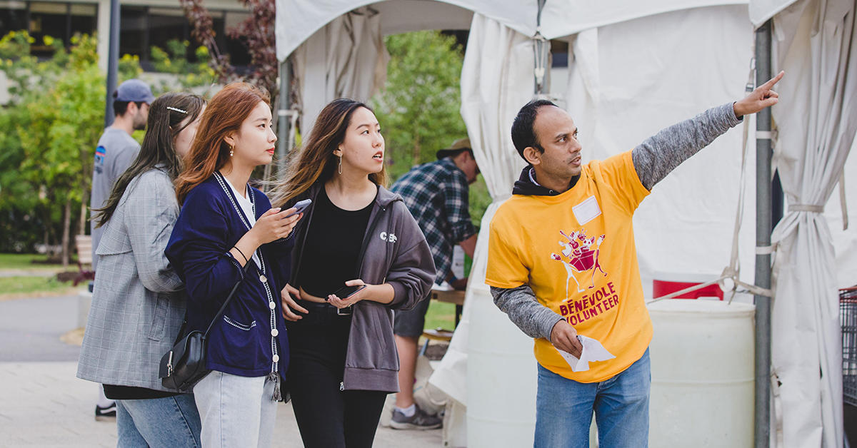 Employé bénévole qui pointe le chemin pour de nouvelles étudiantes en résidence