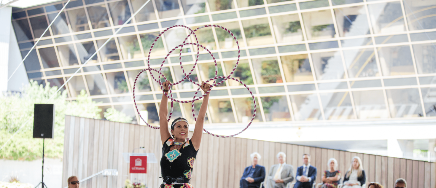 Indigenous hoop dancer performing with five hoops at University Square