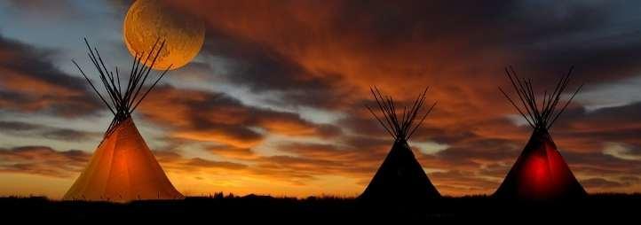 Three tipis in the sunset