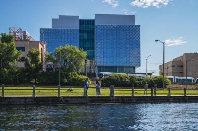 Students by the Rideau canal with STEM complex in the background.