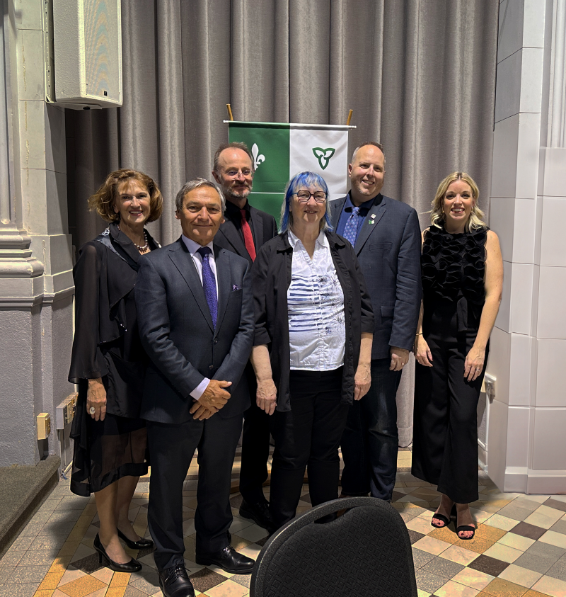 a group of people standing in front of the franco-ontarian flag