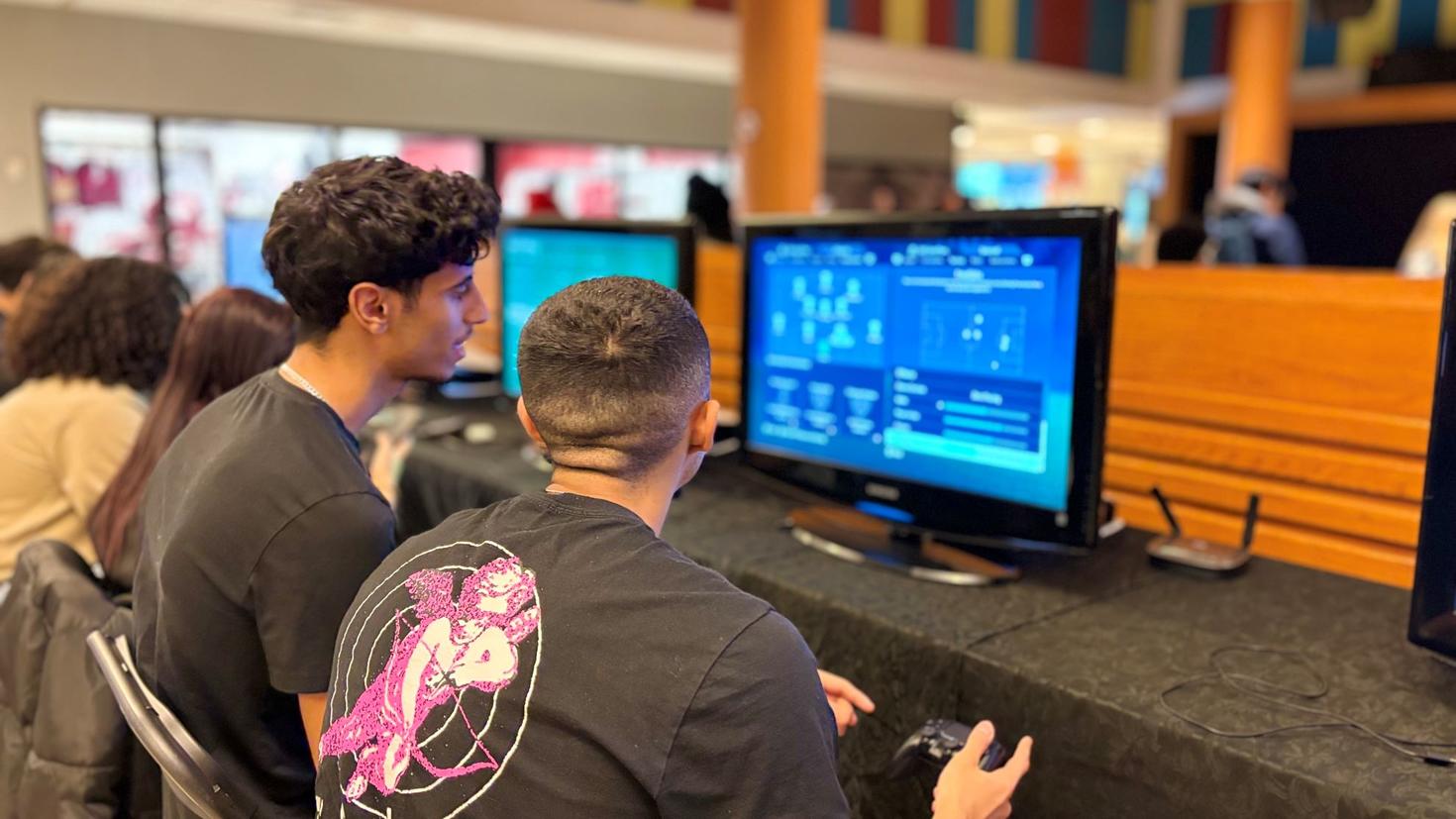 Two students playing a video game.