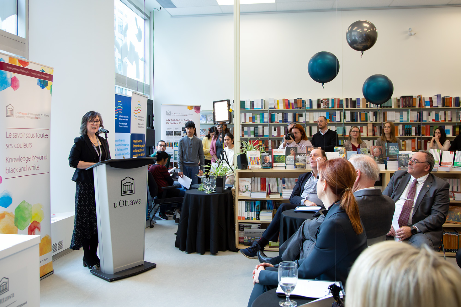 Lara Mainville standing at a podium speaking to a group of people