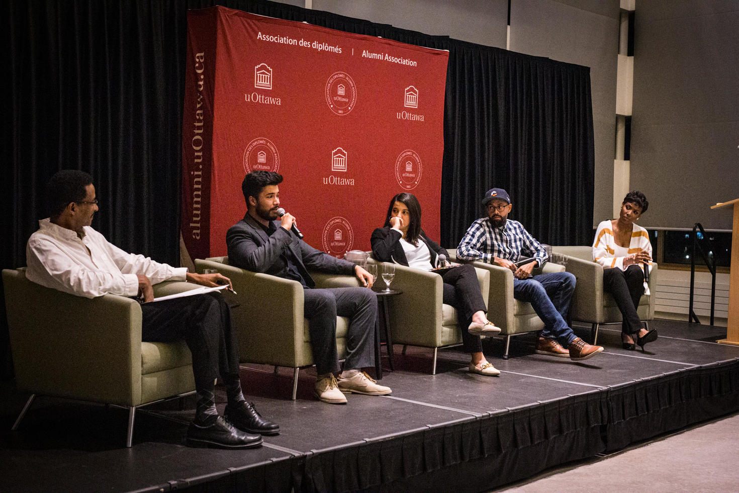 Four speakers on stage, taking part in a panel discussion