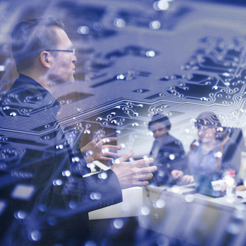 Professor teaching students in class with an overlay of a computer chip.