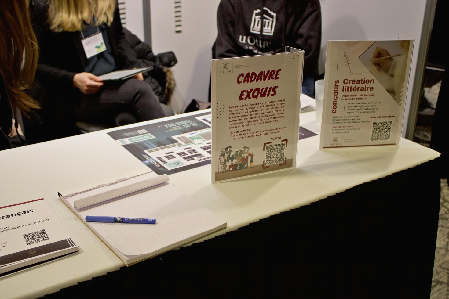 Table du kiosque avec un jeu du cadavre exquis et un concours littéraire pour les élèves du secondaire