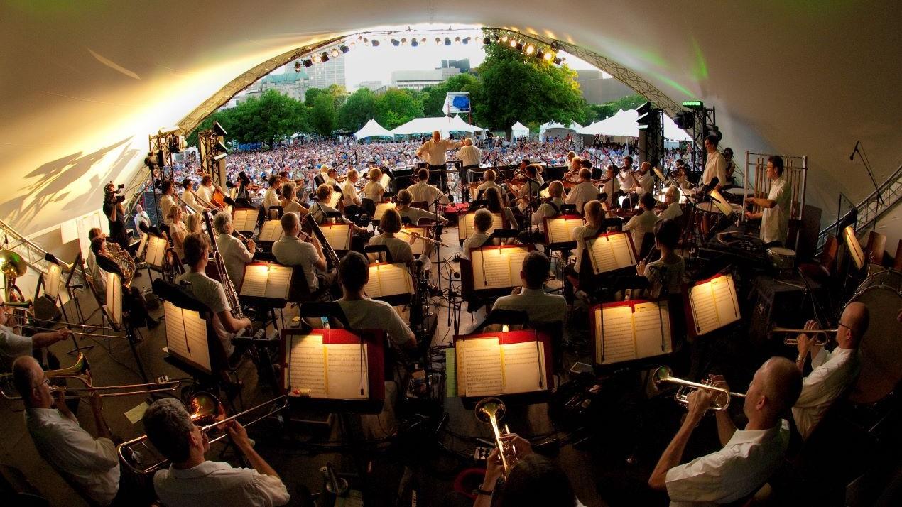 A backstage view of a jazz orchestra performing for a crowd.