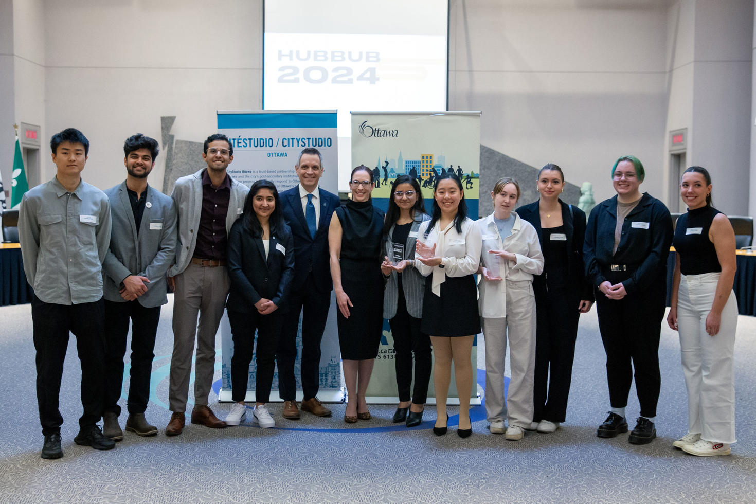 Un groupe d'étudiants se tient en rangée, avec le maire d'Ottawa au centre.