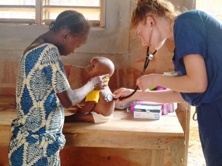 Une étudiante en médecine examine un bébé à l'aide d'un stéthoscope.