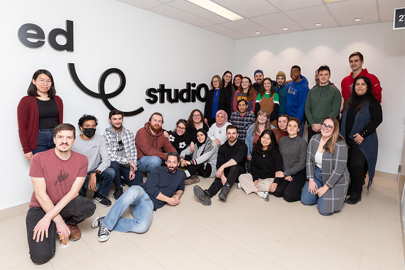Students posing in front of edstudiO logo.