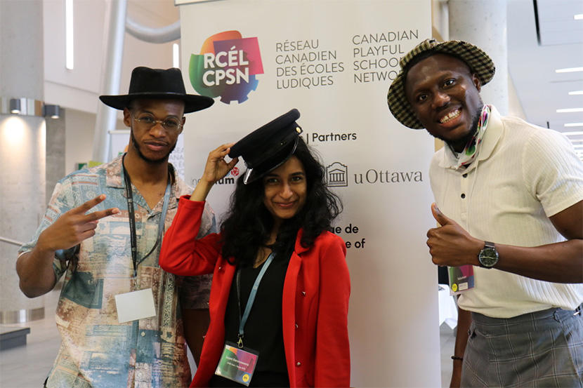 Les membres de la population étudiante souriant devant une bannière de conférence.