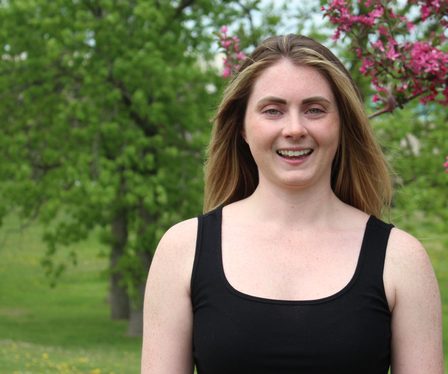 A person standing outdoors with trees in the background