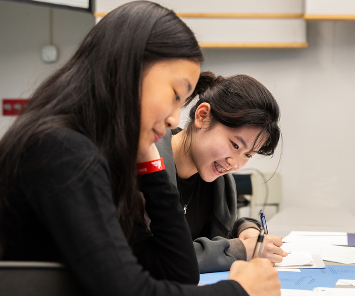 Two participants sit at a table solving a math problem at the 2024 uOttawa Math Camp.