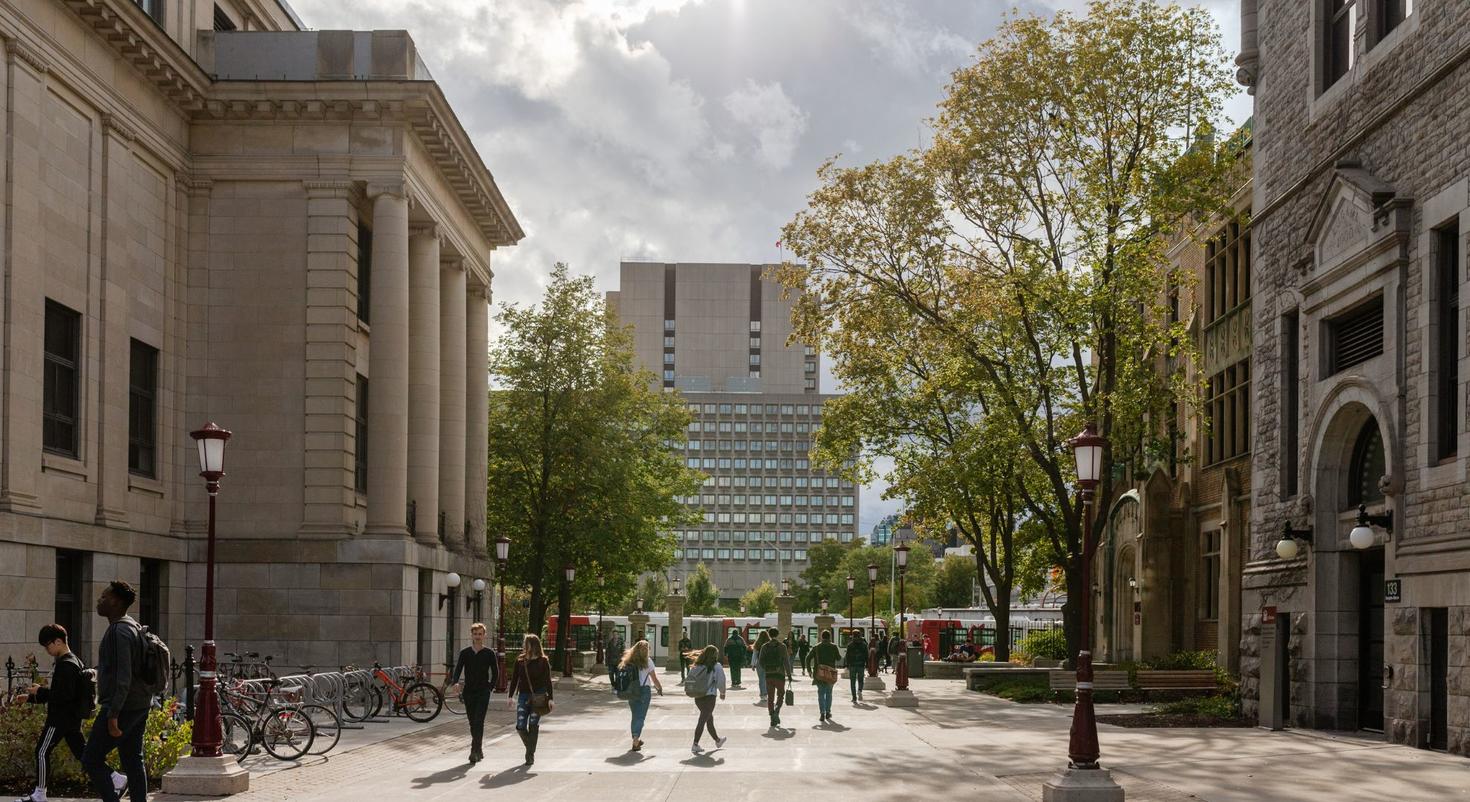 View of campus in the early Fall with people walking between Tabaret Hall and and Hagen.