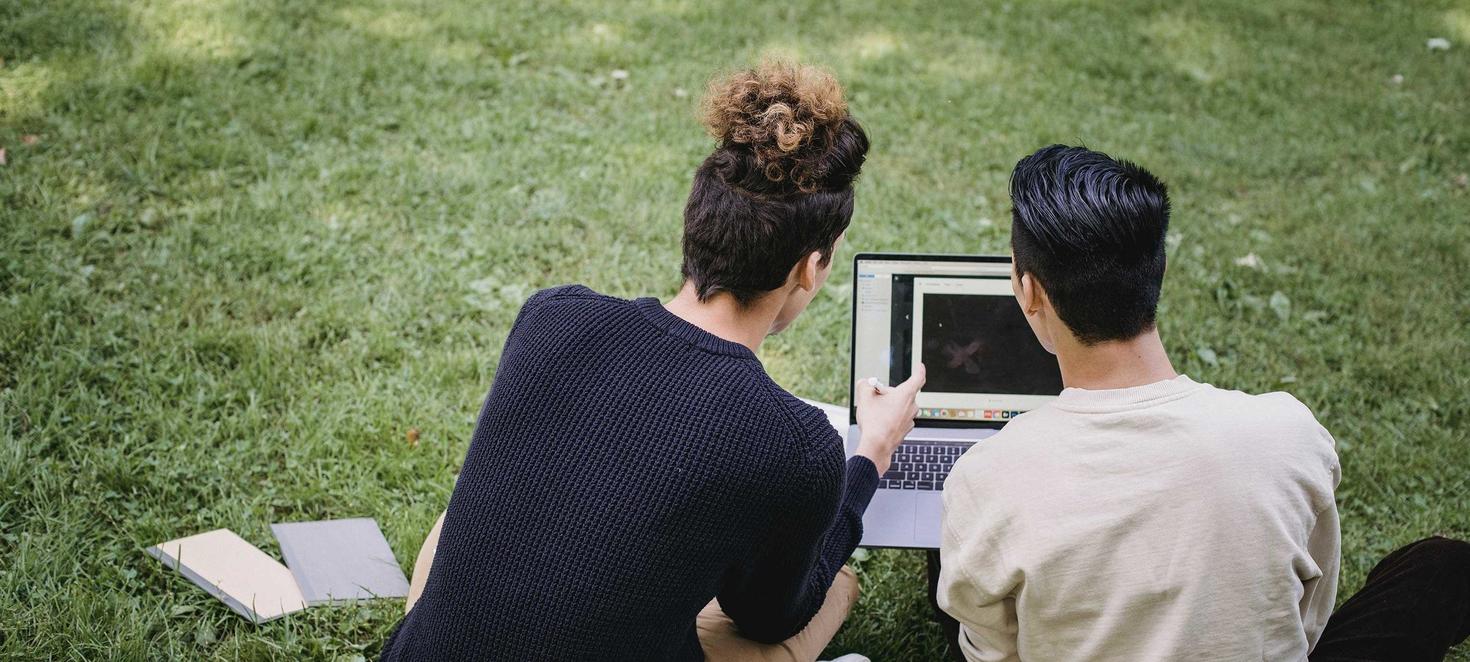 Two students sitting with a laptop