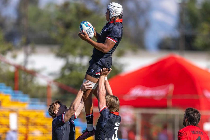 Deux joueurs de rugby des Gee-Gees soulèvent un troisième joueur dans les airs lors d'un alignement.