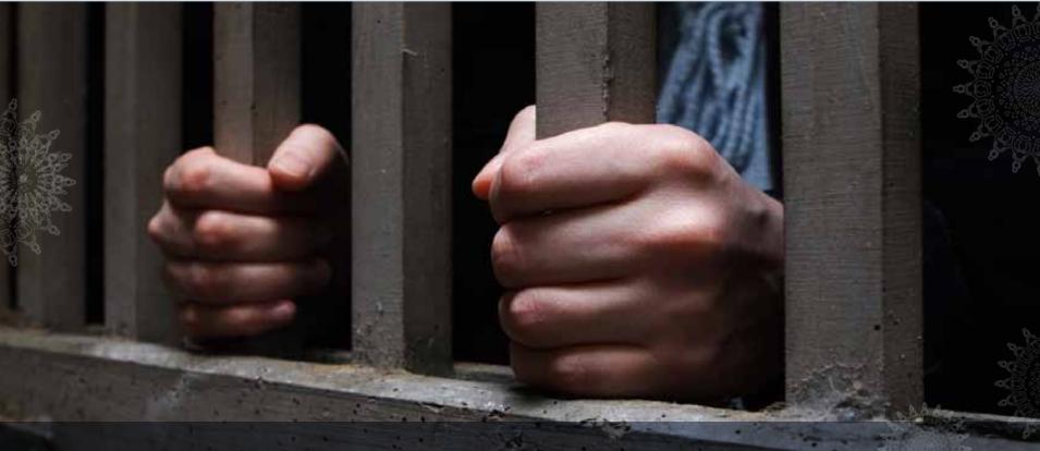 Hands holding on to prison bars