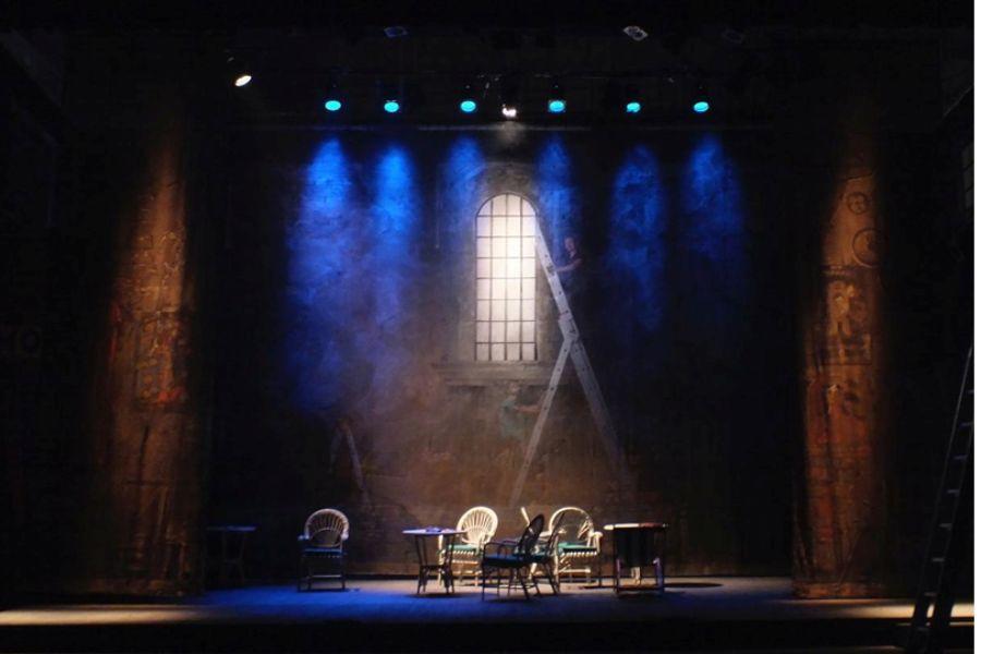 A set of lit chairs and tables on a stage.