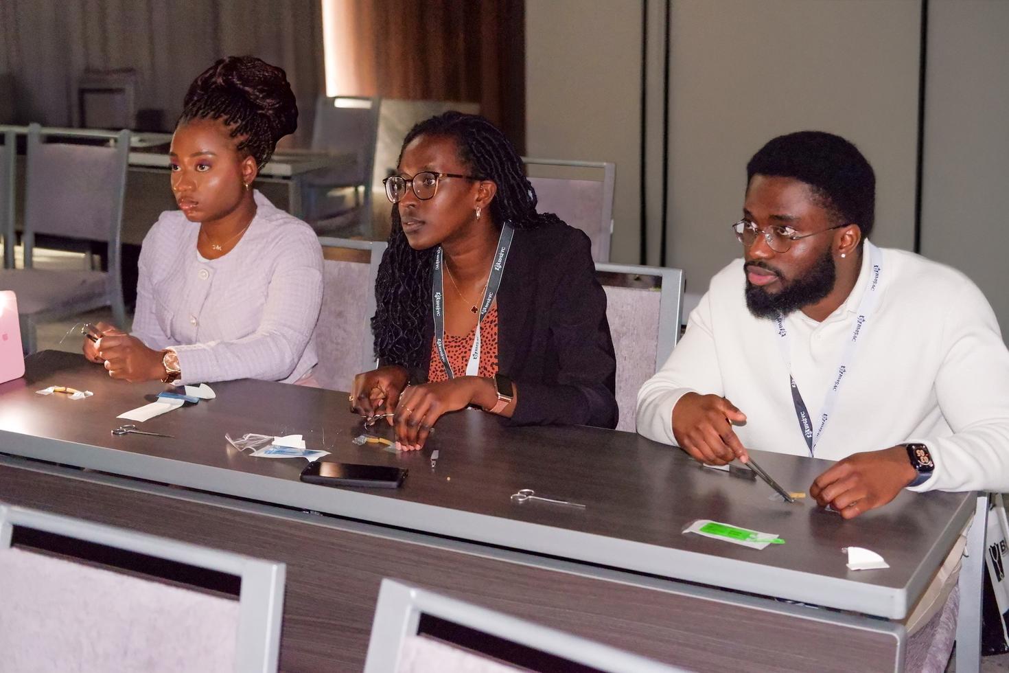 Three medical students learning a medical skill in a classroom